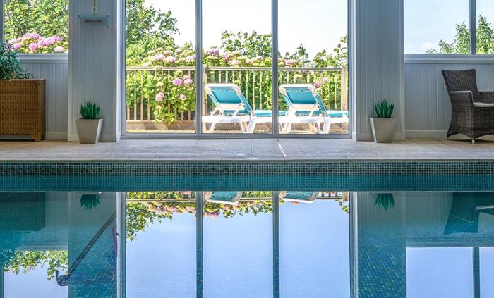 Relax after a long day in our indoor heated swimming pool and spa bath with views over the bay